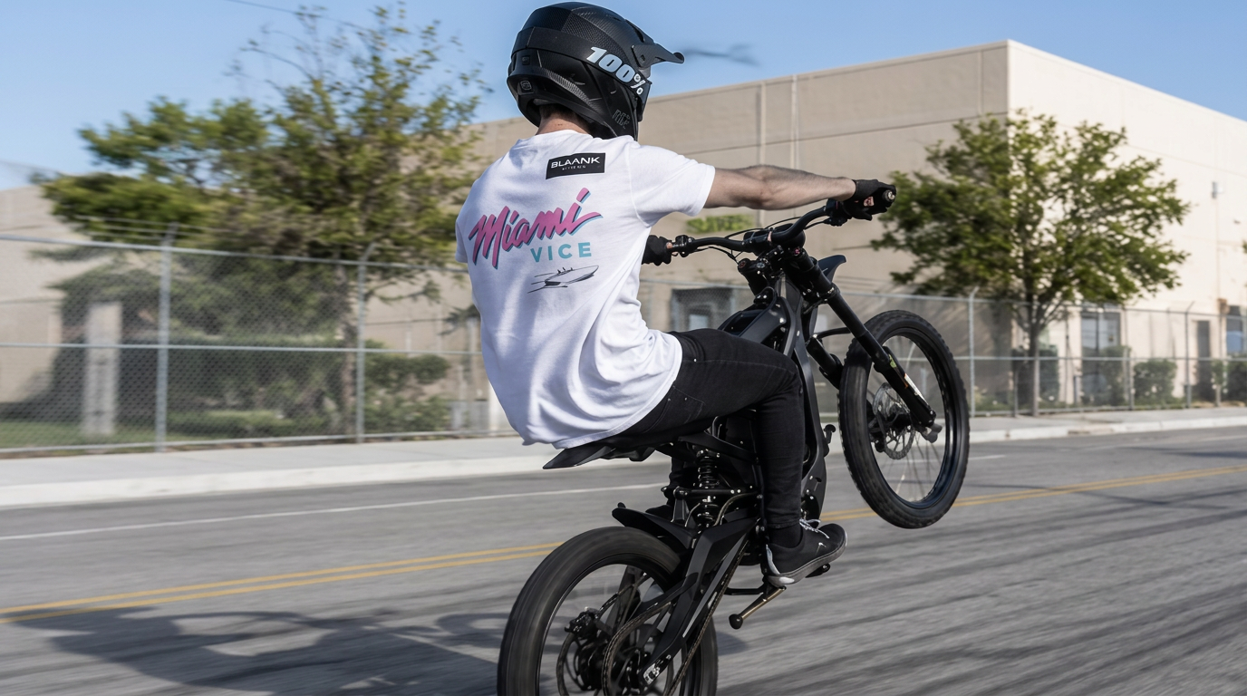 Rider on a high-performance electric bike wearing a Blackout Supply Miami Vice tee on an open street